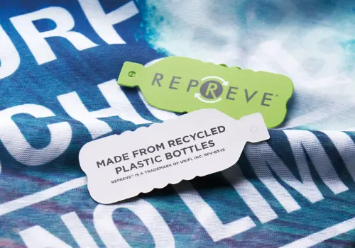 Dettaglio del tessuto riciclato e tag Repreve su scaldacollo personalizzato realizzato in poliestere rPET da bottiglie di plastica riciclate.